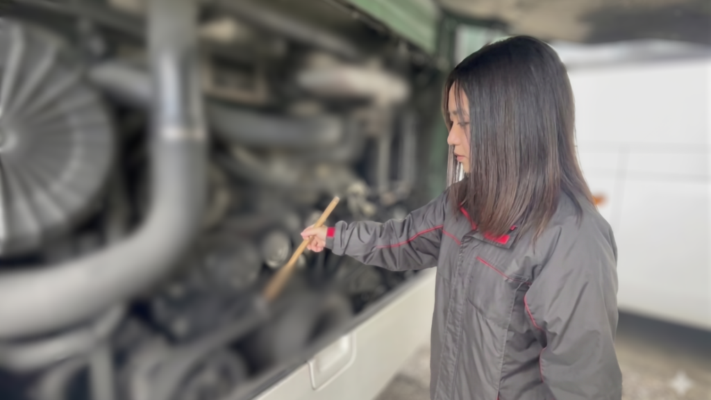 バスの車両点検をするコミタクモビリティサービスの女性社員